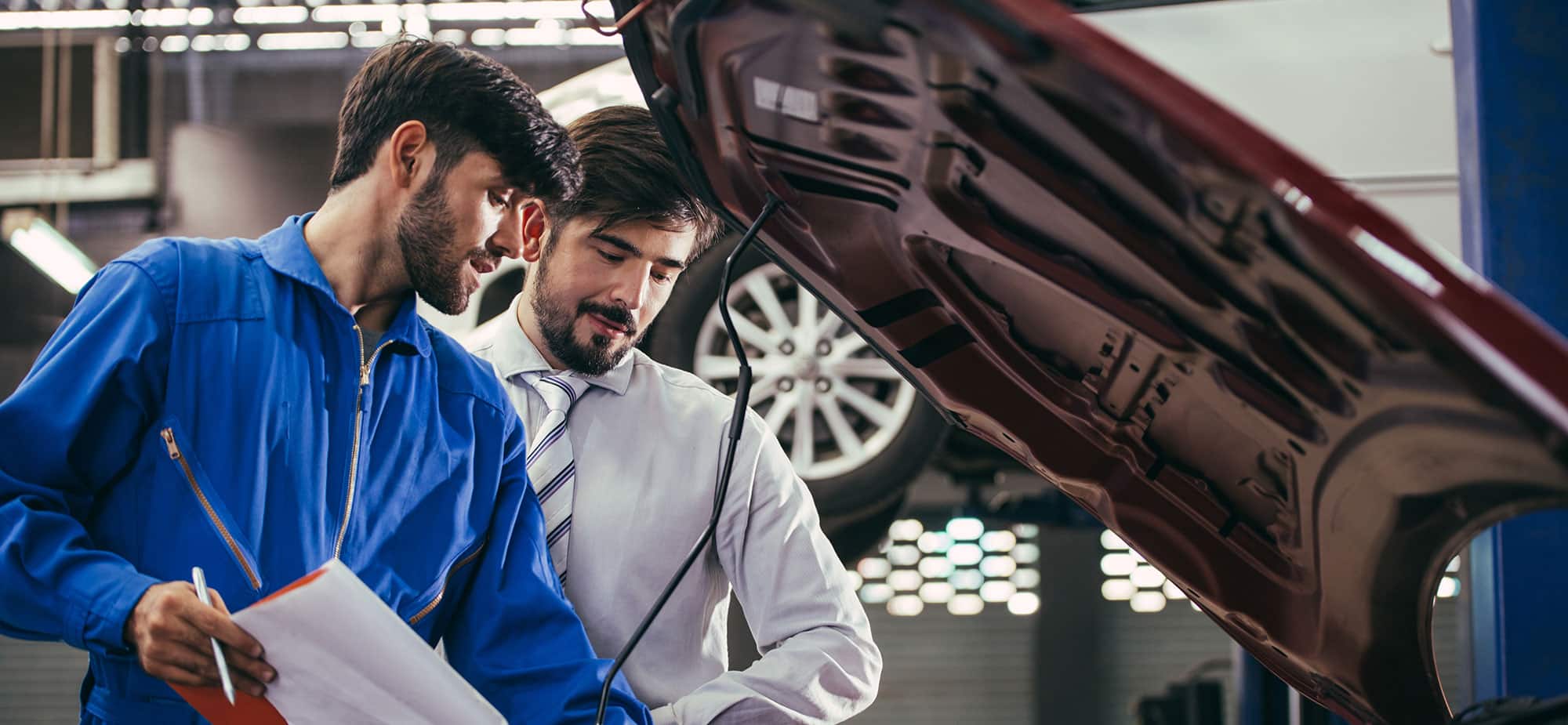 ASE-certified technician reviewing a repair with a customer
